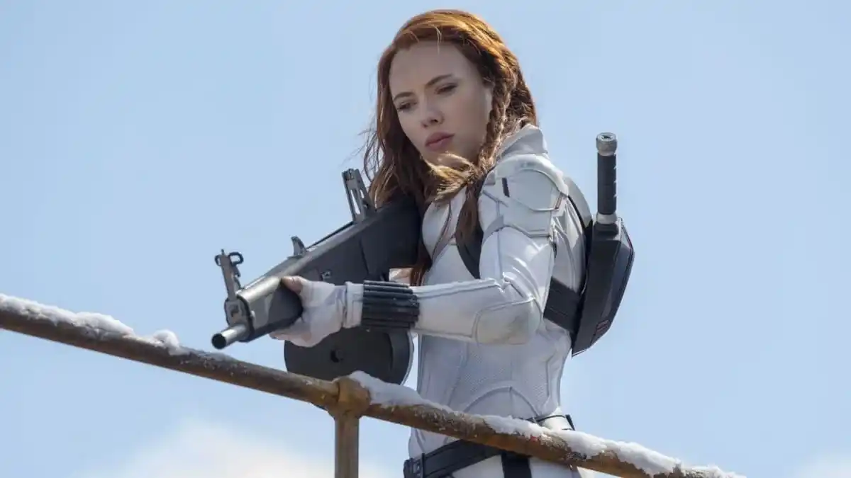 Natasha Romanoff, de Scarlett Johansson, empunha uma arma enquanto veste seu traje de Viúva Branca em uma foto de Viúva Negra.