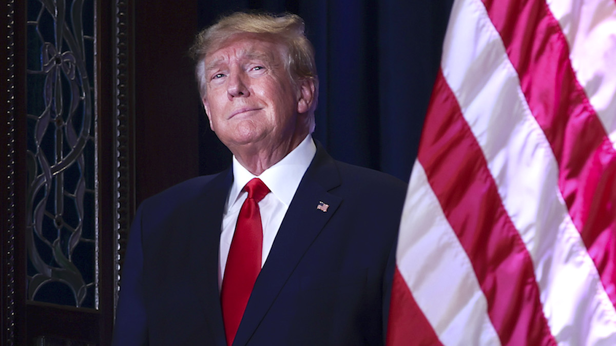 Donald Trump standing next to the American flag