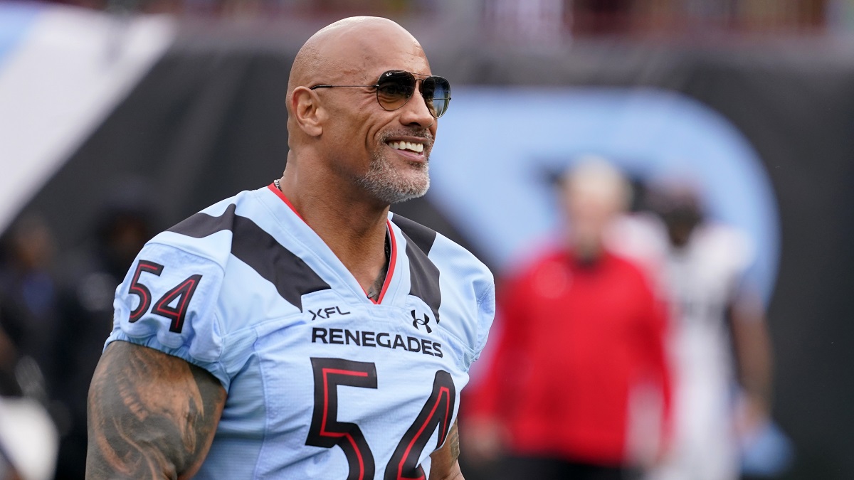 ARLINGTON, TEXAS - FEBRUARY 18: XFL owner Dwayne Johnson stands on the field before the game between the Arlington Renegades and the Vegas Vipers at Choctaw Stadium on February 18, 2023 in Arlington, Texas.