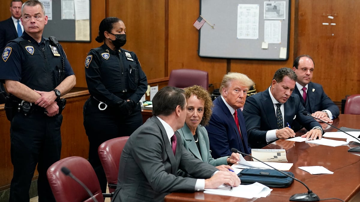 Former U.S. President Donald Trump sits at the defense table with his defense team
