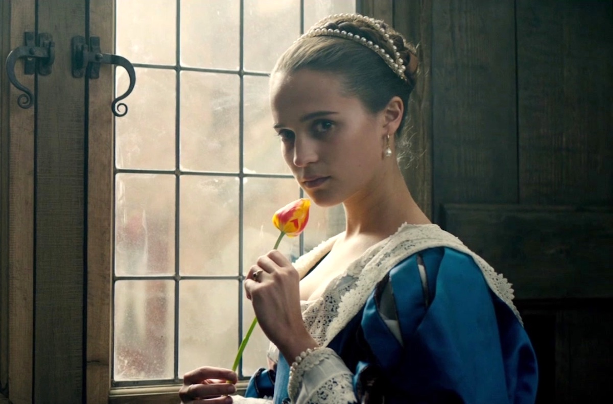 Alicia Vikander holds a flower in Tulip Fever