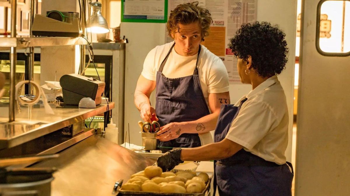 The Bear Carmy (Jeremy Allen White) and Tina (Liza Cólon-Zayas) are talking to one another in The Bear. 