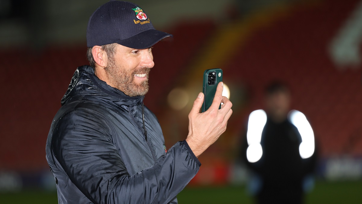 WREXHAM, WALES - APRIL 22: Wrexham co-owners Ryan Reynolds FaceTimes his wife Blake Lively as Wrexham celebrate promotion back to the English Football League during the Vanarama National League match between Wrexham and Boreham Wood at Racecourse Ground on April 22, 2023 in Wrexham, Wales.