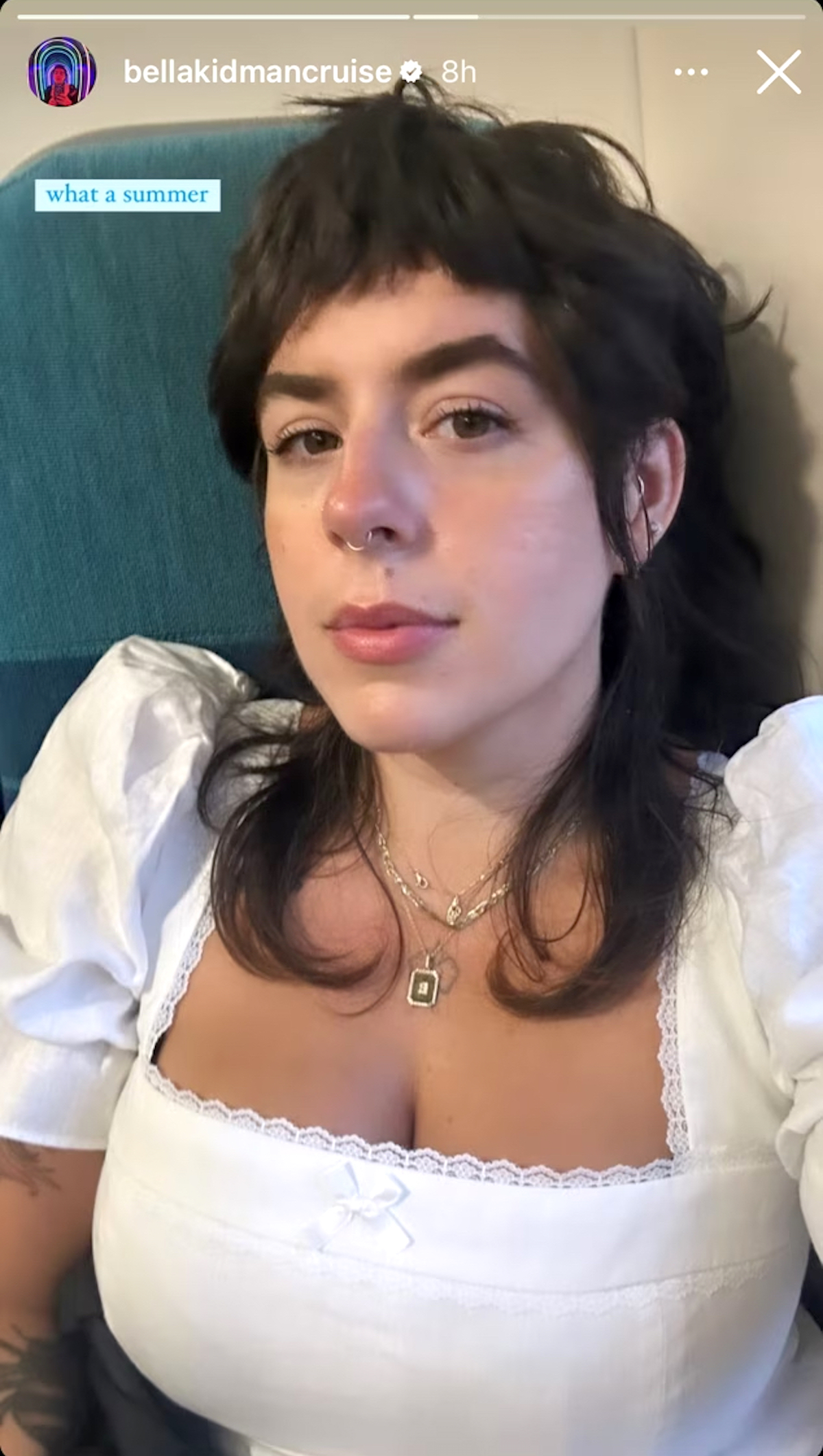 Isabella Jane Cruise wearing a white puff sleeve crop top with a tiny white bow in the middle of her chest and her signature septum ring nose piercing.