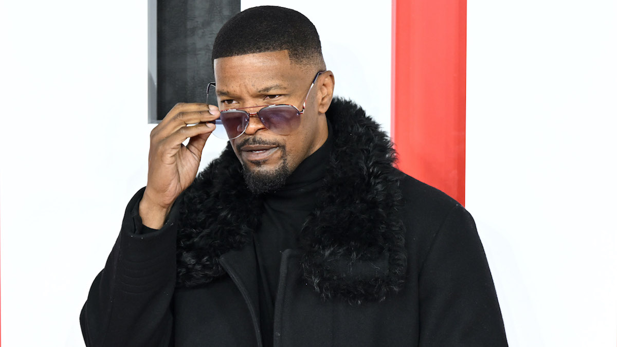 Jamie Foxx at the "Creed III" European Premiere, dressed in an all-black suit and fur jacket