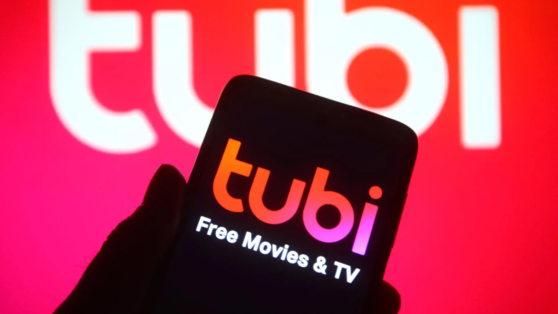 A phone is held up that says "Tubi free movies & TV". 