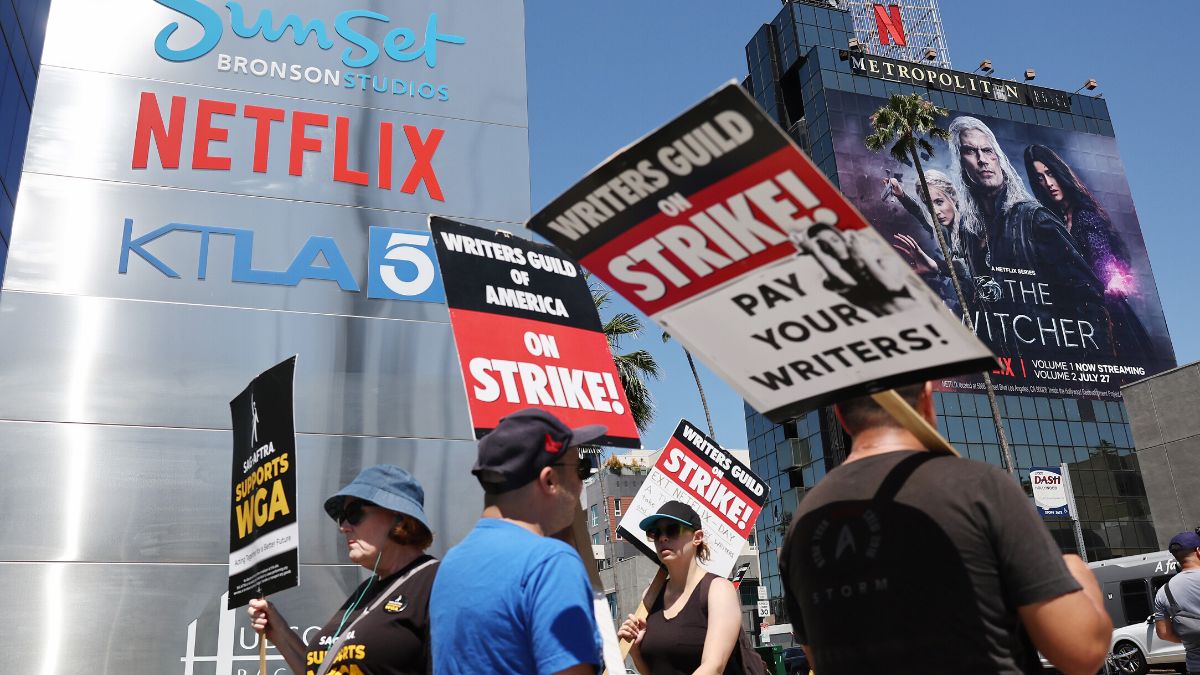 LOS ANGELES, CALIFORNIA - JULY 11: People carry signs as SAG-AFTRA members walk the picket line in solidarity with striking WGA (Writers Guild of America) workers outside Netflix offices on July 11, 2023 in Los Angeles, California. Industry insiders concerned about the possibility of a potential actors’ strike will have to wait a little bit longer to know for sure. SAG-AFTRA and top studios and streamers have agreed to extend their current contract negotiations until July 12 at 11:59 p.m.