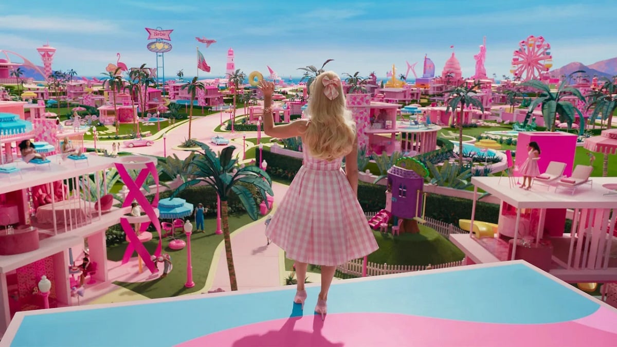 Barbie is standing on the roof, waving. 