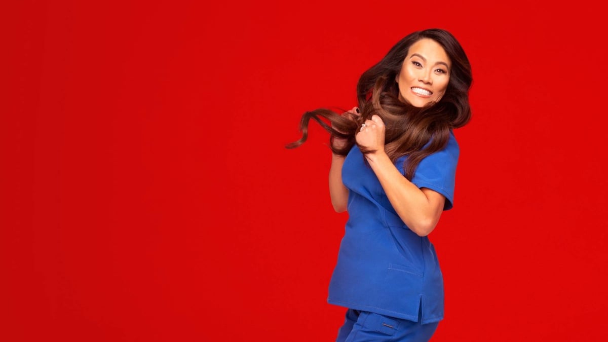 Dr. Sandra Lee jumping for joy against a red background