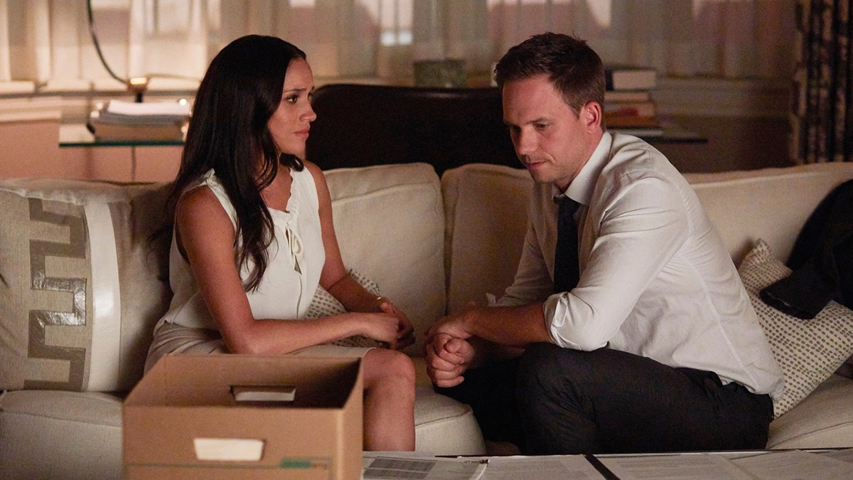 Rachel Zane (Meghan Markle) and Mike Ross (Patrick J. Adams) sit on a sofa in Suits