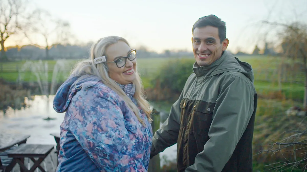Kadie and Alejandro hold hands in the English countryside