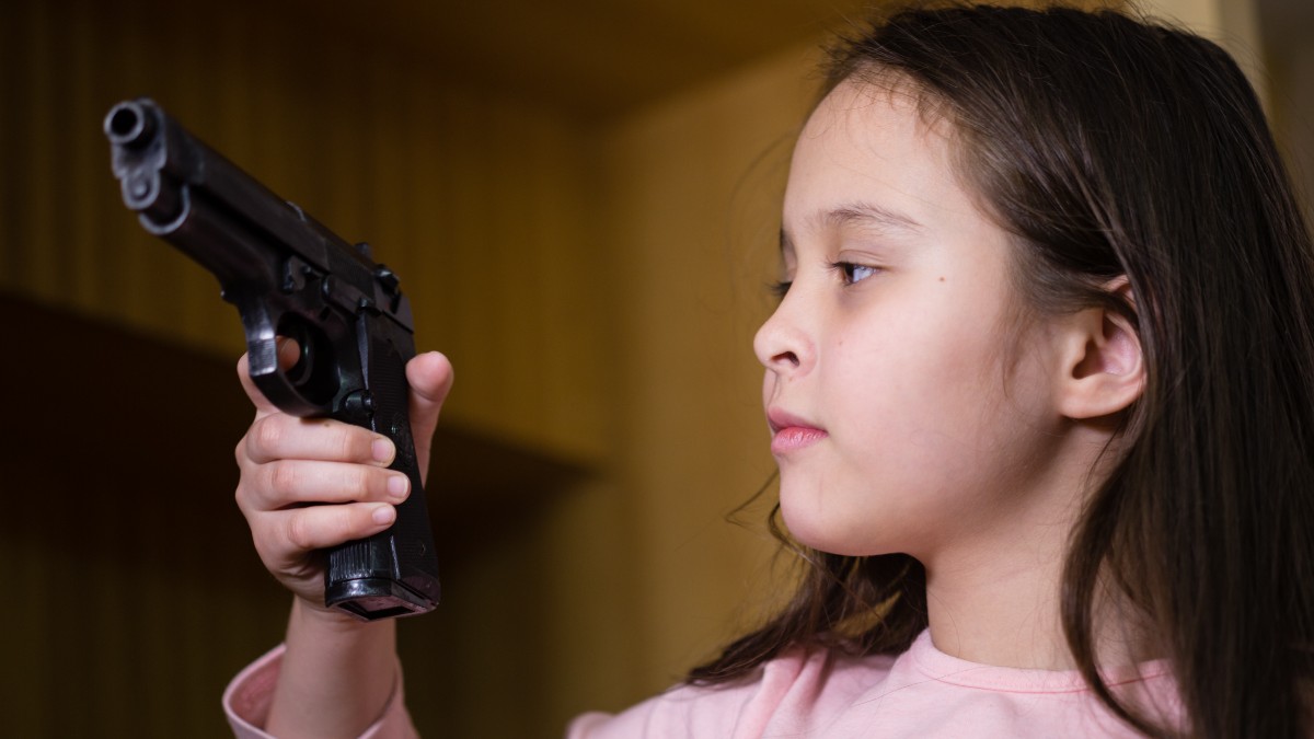 Young child finds pistol in cupboard, gun control concept