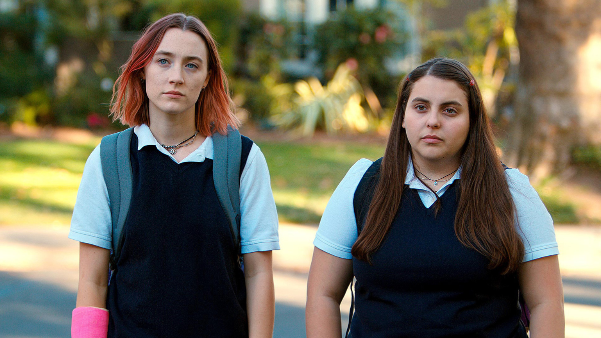 Lady Bird and Julie stand together in their Catholic school uniforms 