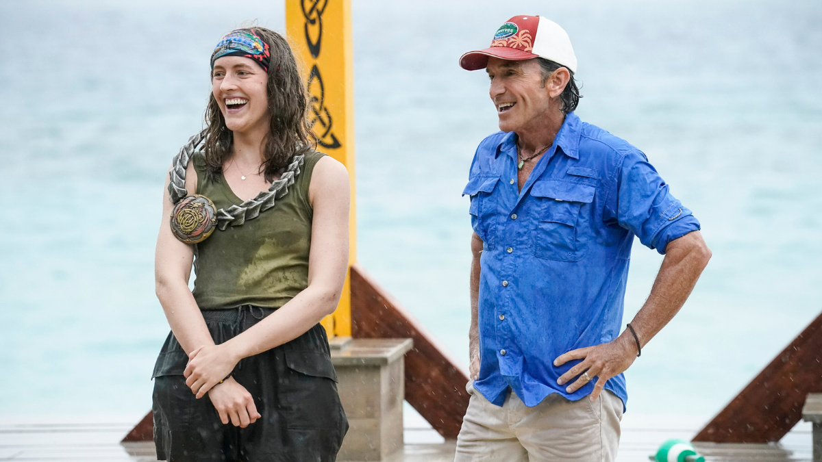 Frannie is seen standing next to longtime host Jeff Probst at an immunity challenge, wearing a green tank top, black shorts, and the coveted immunity necklace.