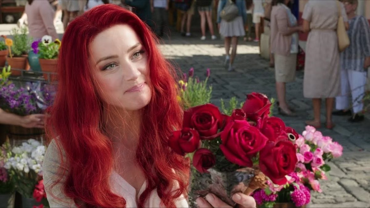 Amber Heard holds a bouquet of roses as Mera in 'Aquaman'