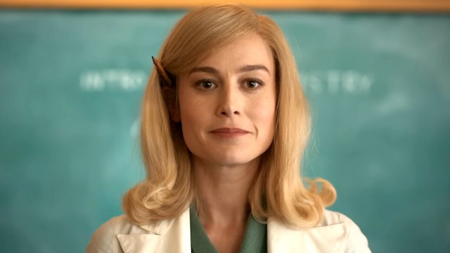 Brie Larson as Elizabeth Zott wearing a lab coat and standing in front of a chalkboard in Apple TV Plus' Lessons in Chemistry