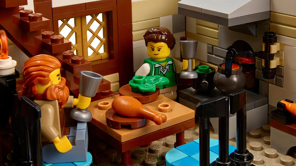 A scene of two figurines sitting down for dinner from the LEGO Ideas Medieval Blacksmith set