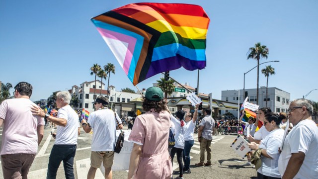 A participant waves the Progress Pride flag at the Long Beach Pride 40th Annual Parade on August 06, 2023 in Long Beach, California.
