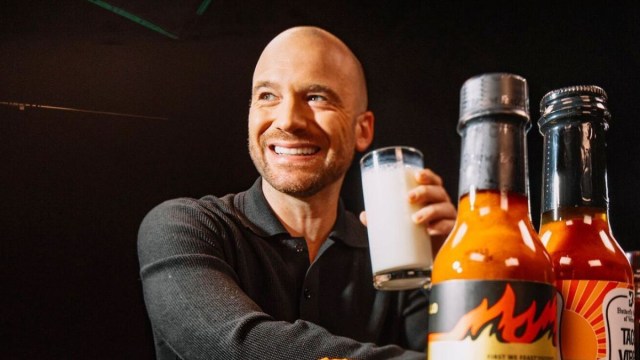 Sean Evans drinks milk in front of hot sauces as host chicken wing interview series 'Hot Ones'