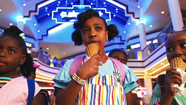 Priah Ferguson as Erica Sinclair in Season 3 of 'Stranger Things' eating ice cream with her friends.