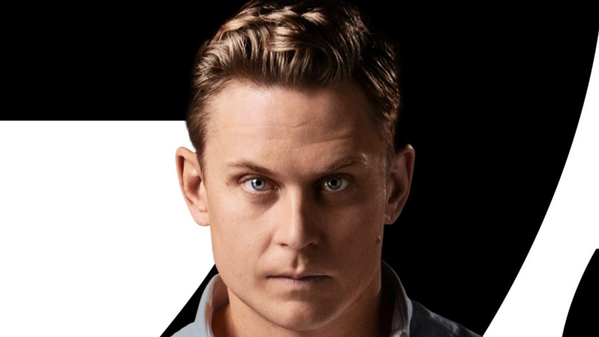 Billy Magnussen is Logan Ash in a cropped character poster for 'No Time to Die' 