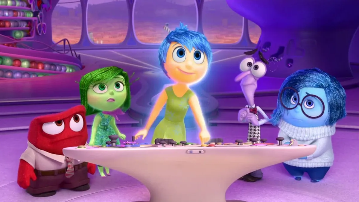 The emotions in Inside Out are all standing together in front of a console.