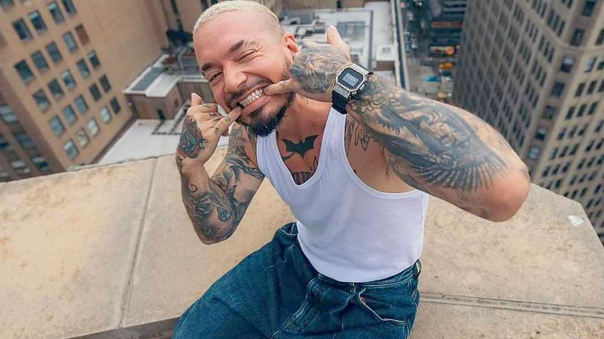 J Balvin posing on top of a building