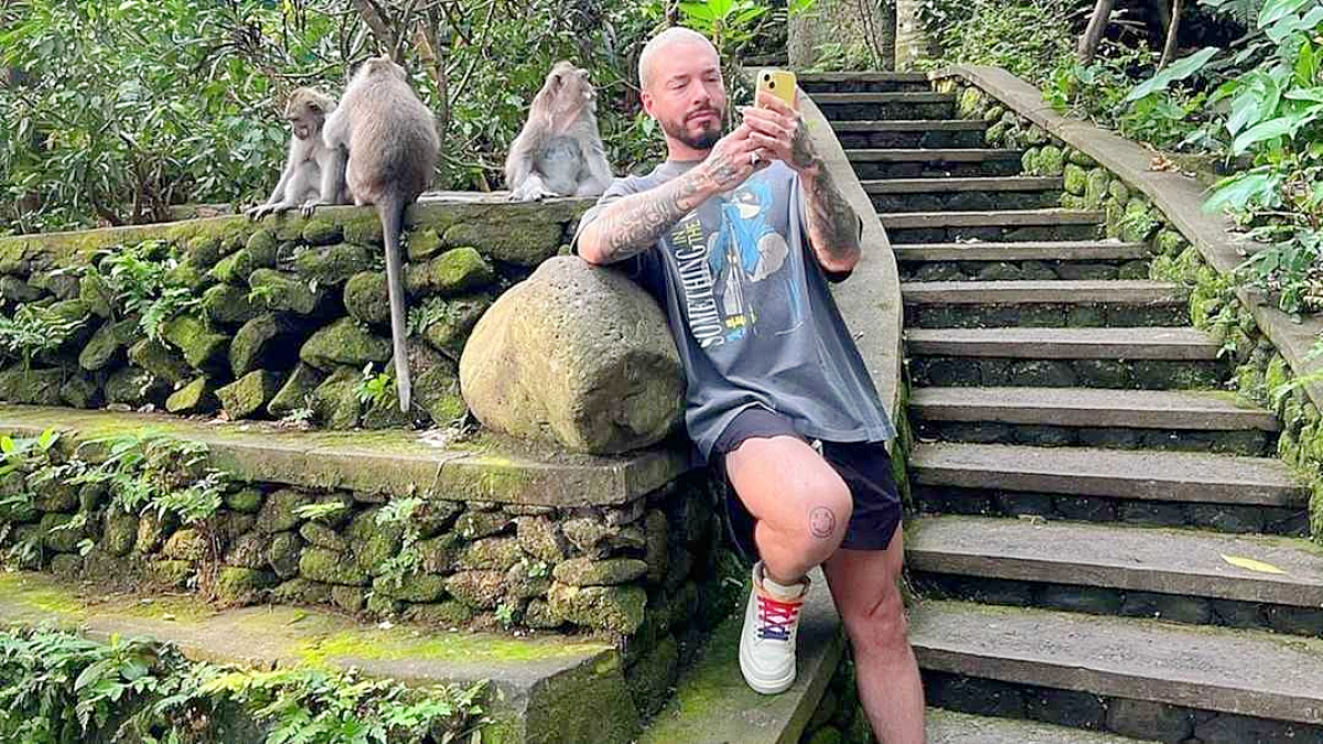 J Balvin posing alongside monkeys