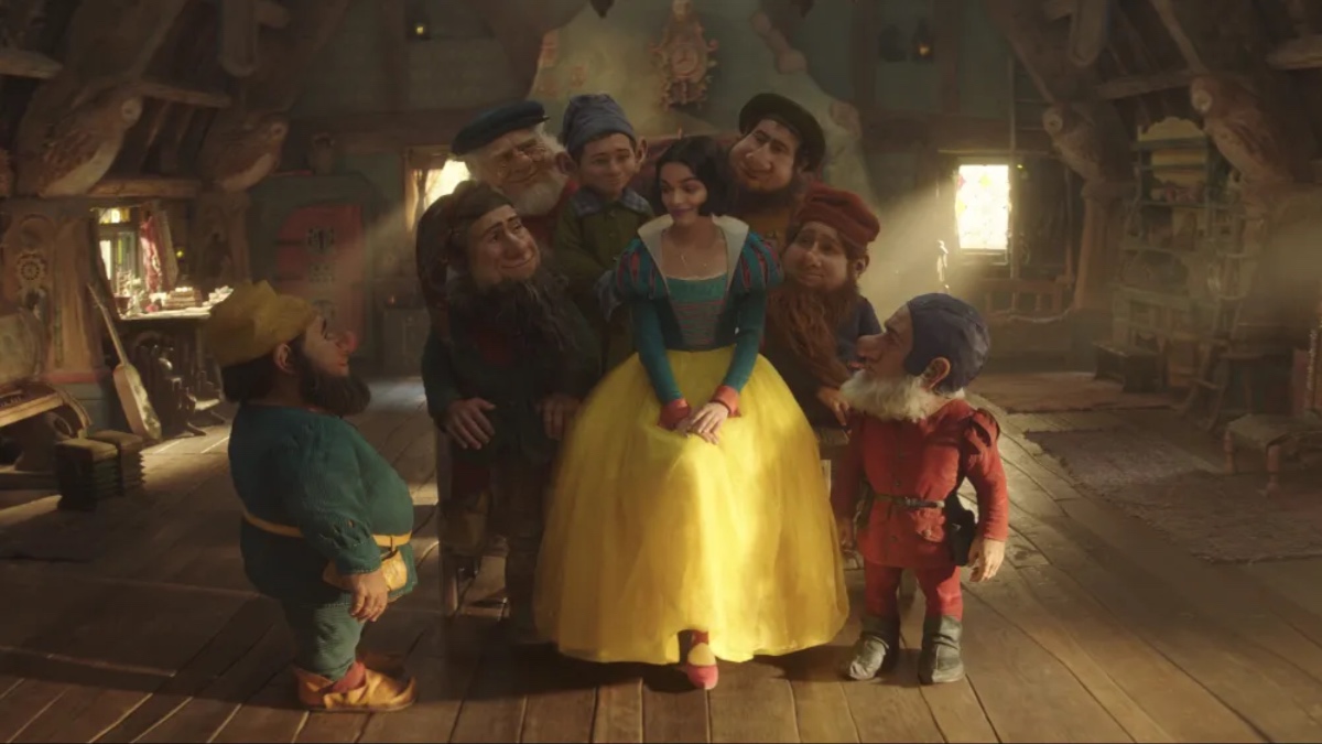 Snow White (Rachel Zegler) surrounded by the seven dwarves