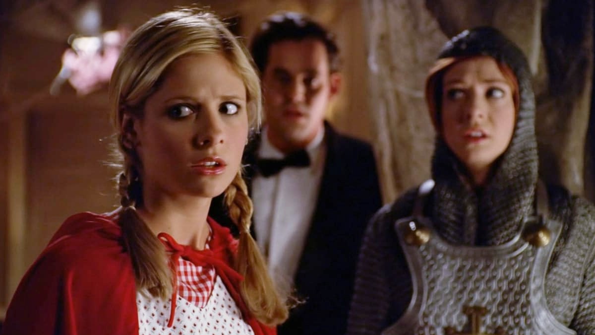 Buffy (dressed as Little Red Riding Hood), Xander (in James Bond cosplay) and Willow (as Joan of Arc) look on in fear in 'Buffy the Vampire Slayer' episode Fear Itself.