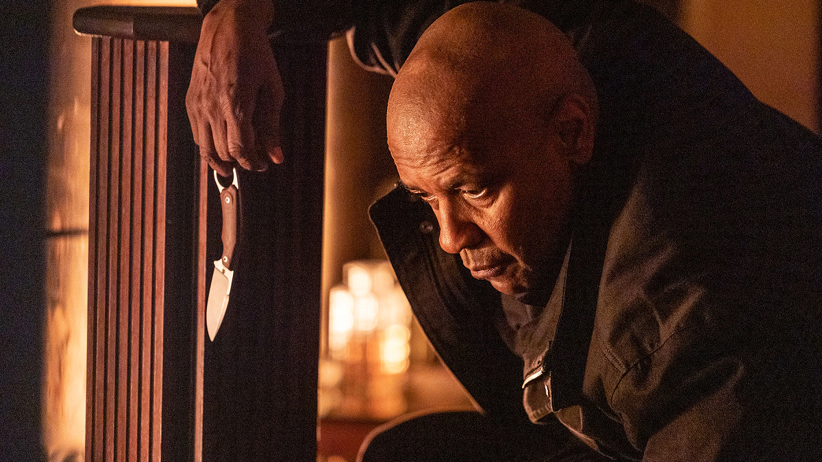 Denzel Washington is holding a knife near a fireplace in The Equalizer 3.
