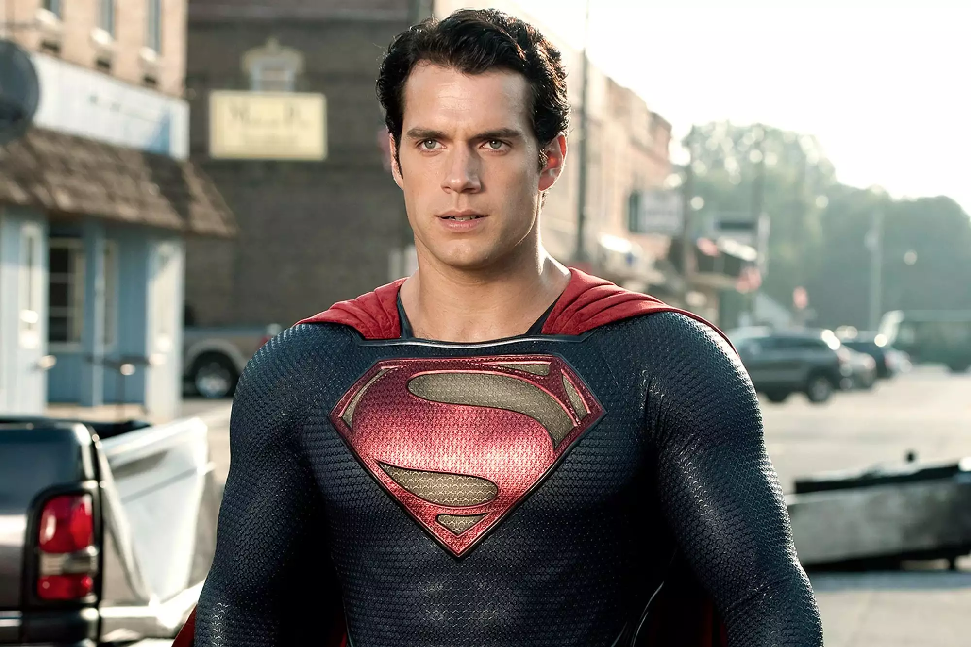 Henry Cavill is in a Superman suit and is looking into the distance.