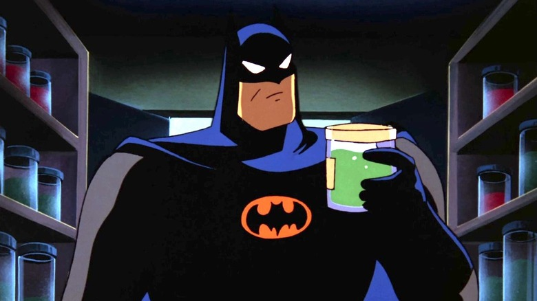 Batman looks at a jar of a green substance. 