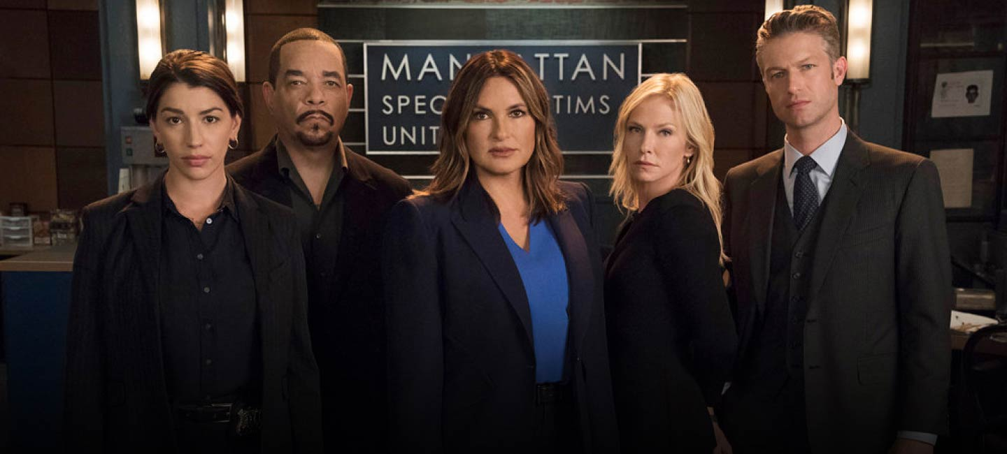 The cast of Law and Order SVU poses for a picture in front of the "Manhattan Special Victims Unit" sign.
