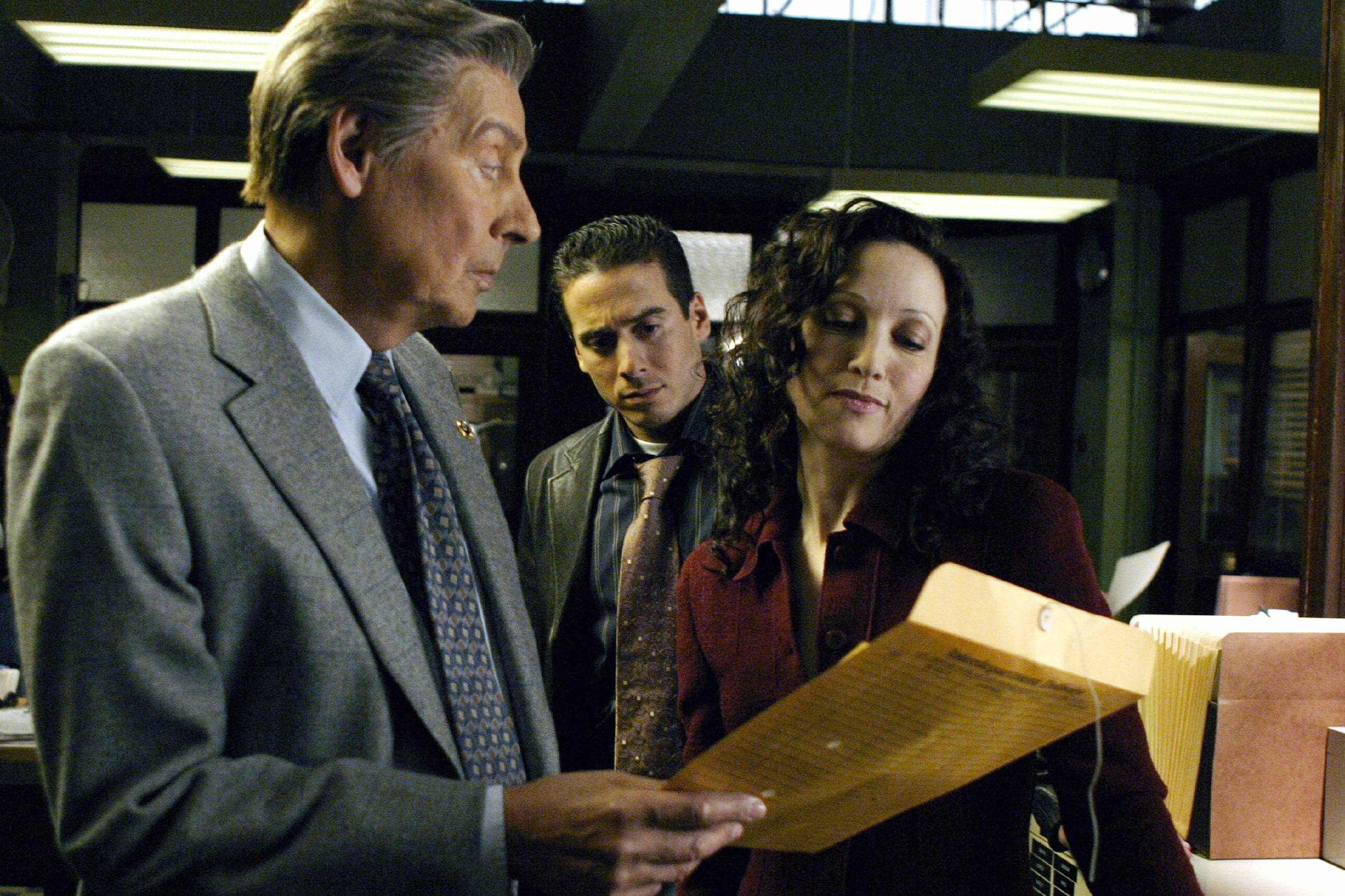 Detectives are looking at a case file on Law & Order: Trial by Jury.
