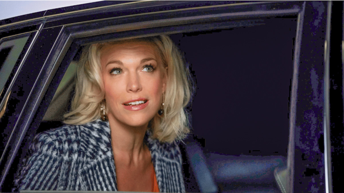 Rebecca Welton (Hannah Waddingham) is glimpsed through an open car door in a promo image for Ted Lasso. 