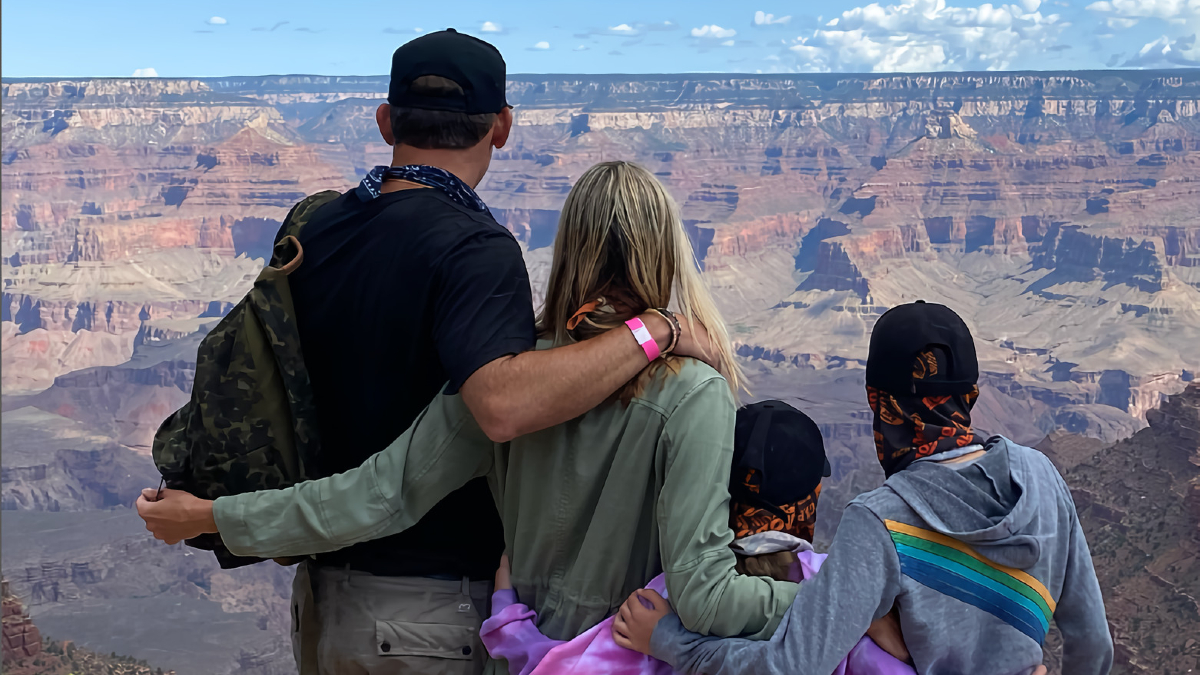 Josh Taekman standing with his family looking out on the grand canyon.