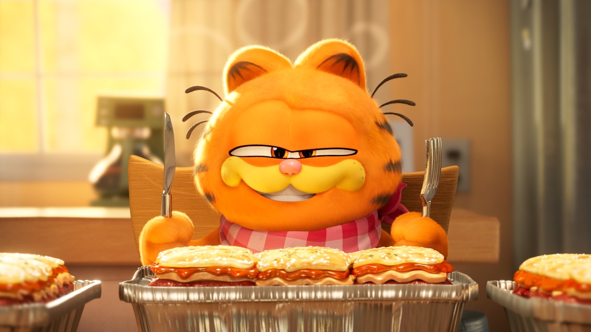 Garfield sitting in front of a tray of lasagna in 2024's 'The Garfield Movie'