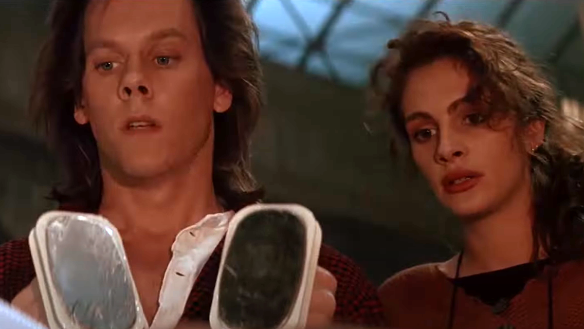 Kevin Bacon holding defibrillation paddles while Julia Roberts watches in 'Flatliners'