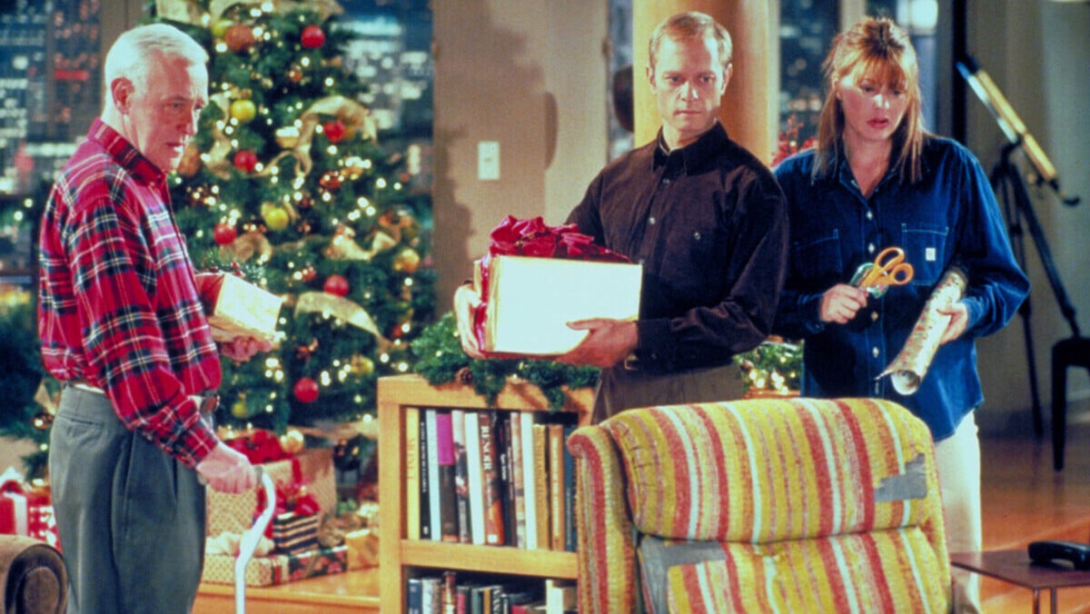 John Mahoney as Martin Crane, David Hyde Pierce as Niles Crane and Jane Leeves as Daphne Moon star in NBC''s television comedy series "Frasier." Episode: "Mary Christmas" - Martin, Niles and Daphne open Christmas presents as they watch Frasier host the holiday parade. 