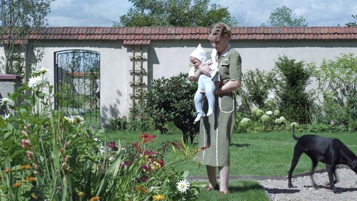 The Zone of Interest -  Hedwig Höss shows her baby a garden planted near the border wall of Auschwitz concentration camp