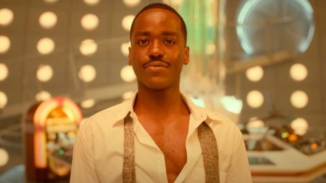 Ncuti Gatwa's Fifteenth Doctor wears an open shirt and undone tie as he stands in his TARDIS in Doctor Who: The Giggle.