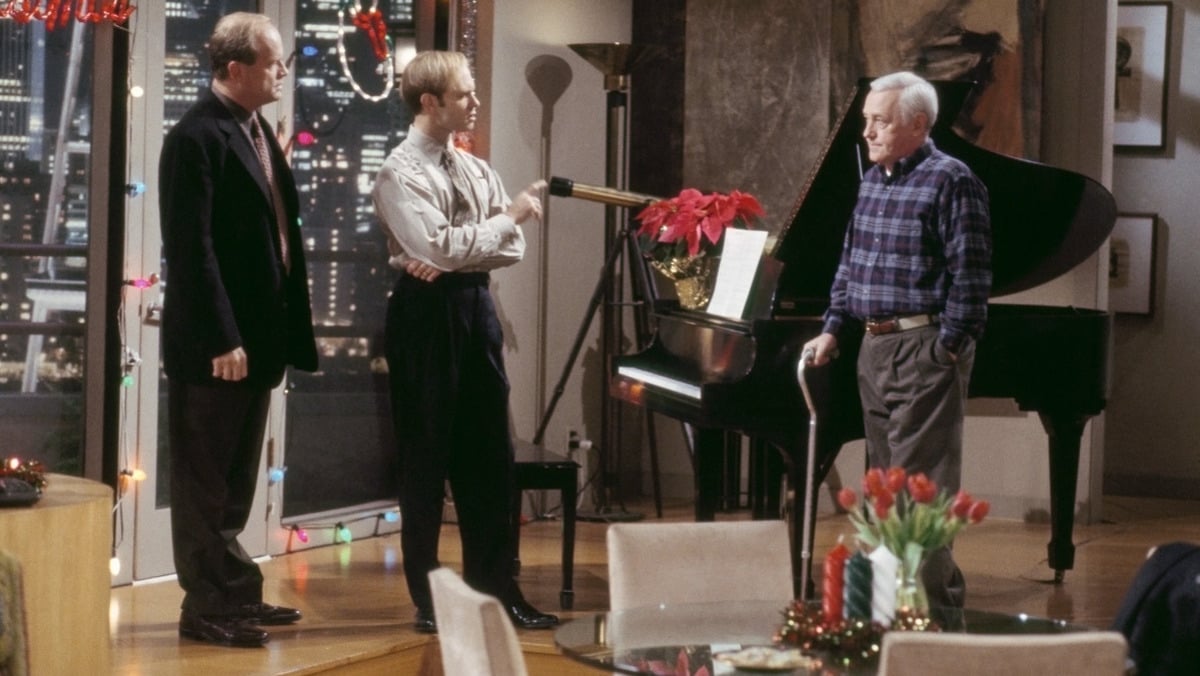 Niles and Frasier gather around the piano to give Martin singing lessons in Frasier: Perspectives on Christmas