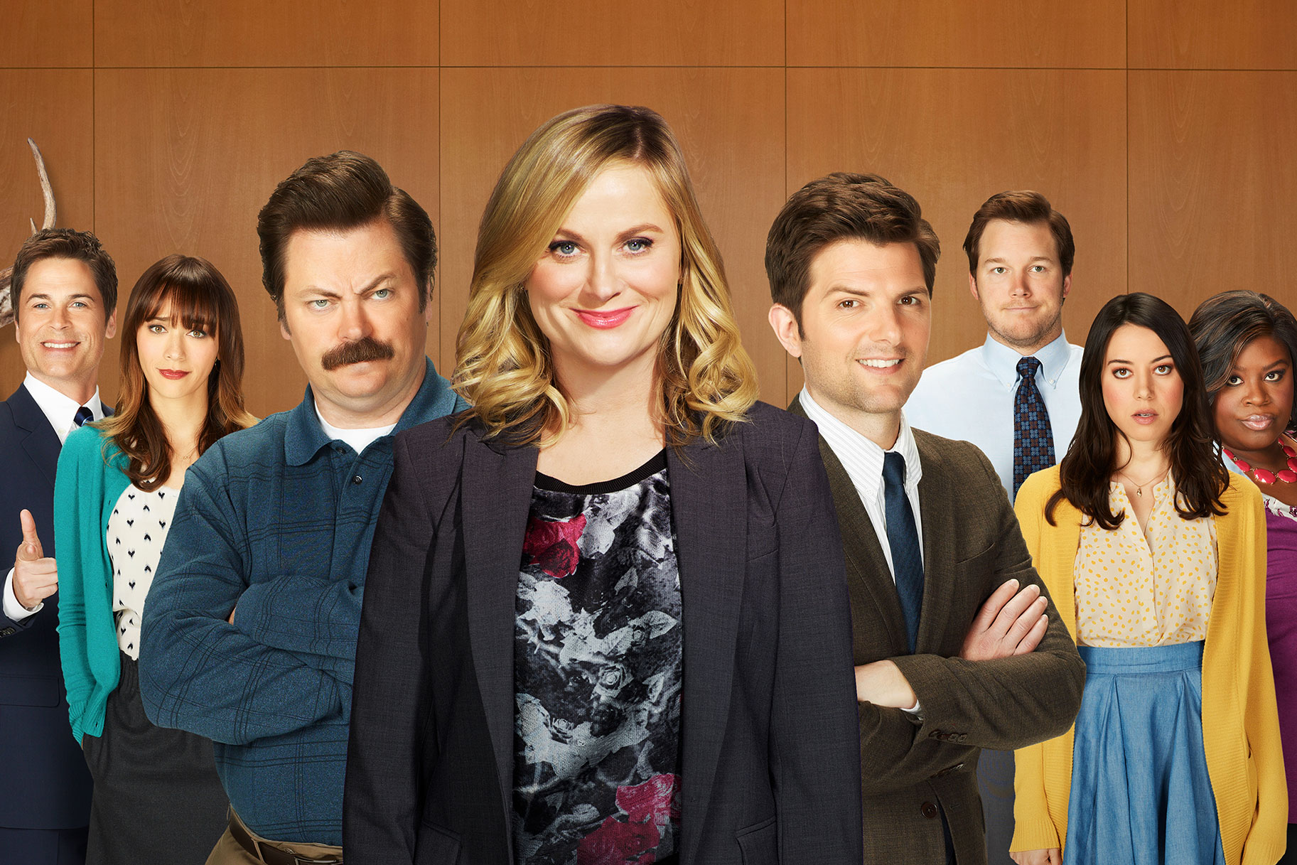 The cast of Parks and Rec are posing together. 