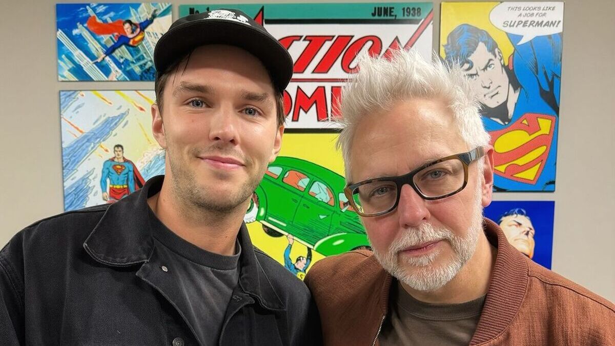 James Gunn and Nicholas Hoult pose in front of Superman wall art 