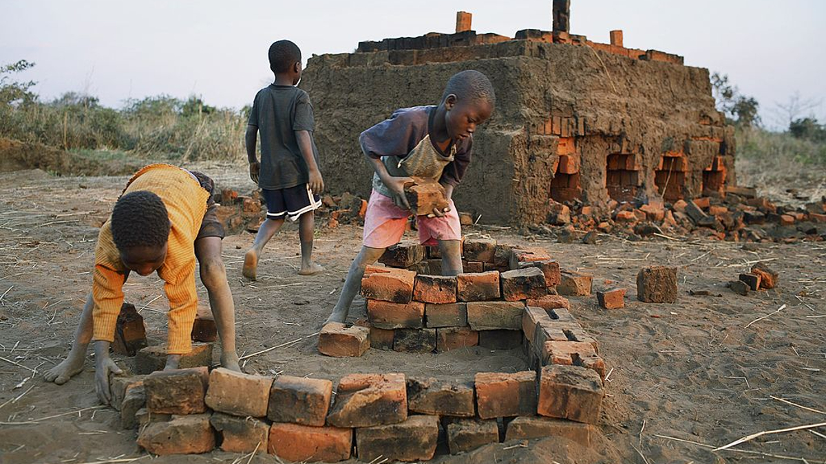 Unidentified children carry bricks from an oven on August 17, 2006 in Mphandula village, about 30 miles outside Lilongwe, Malawi. Mphandula is a poor village in Malawi, without electricity or clean water. Nobody owns a car or a mobile phone. Most people live on farming. About 7000 people reside in the village and the chief estimates that there are about five-hundred orphans. Many have been affected by HIV/Aids and many of the children are orphaned. A foundation started by Madonna has decided to build an orphan center in the village through Consol Homes, a Malawi based organization. Raising Malawi is investing about 3 million dollars in the project and Madonna is scheduled to visit the village in October 2006. Malawi is a small landlocked country in Southern Africa without any natural resources. Many people are affected by the Aids epidemic. Malawi is one of the poorest countries in the world and has about 1 million orphaned children. 