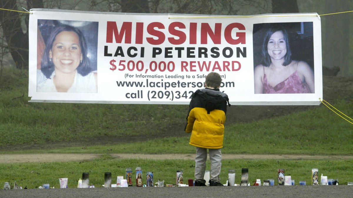 A young child stops to look at a makeshift memorial and a missing person's banner offering a half-million dollar reward for the safe return of Laci Peterson at the East La Loma Park January 4, 2003 in Modesto, California. Peterson, who is eight-months pregnant, has been missing since December 24, 2002 when she allegedly took her dog for a walk in the park while her husband was on a fishing trip. (Photo by Justin Sullivan/Getty Images)