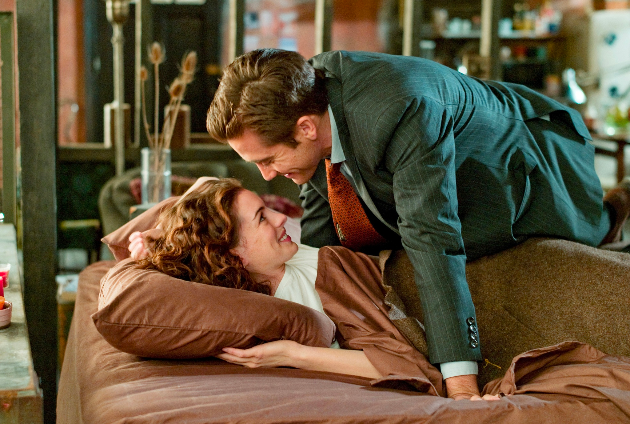 Anne Hathaway and Jake Gyllenhaal are looking at each other in Love and Other Drugs.