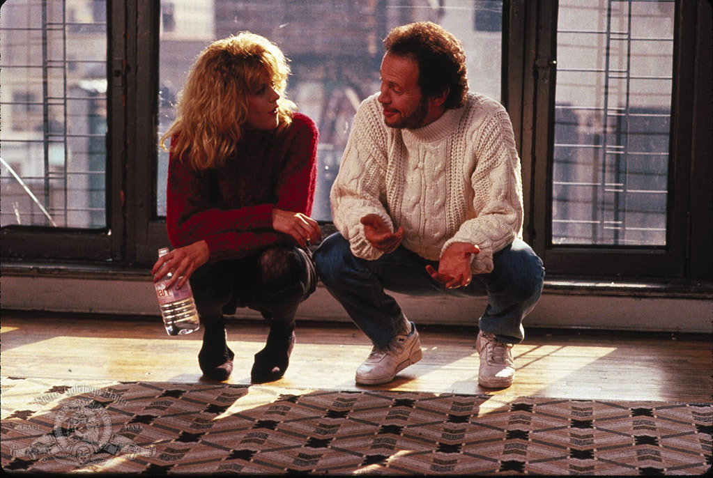 Two characters are kneeling and talking to each other in Harry Met Sally.