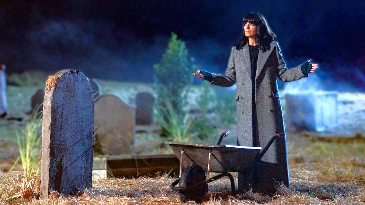 Host Claudia Winkelman stands in a graveyard at night in The Traitors UK season 2 episode 6